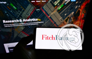 Logo Fitch Ratings wyświetlone na ekranie smartfona na tle platformy Research & Analytics - jedna z trzech największych agencji ratingowych na świecie